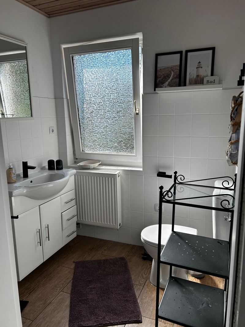 Badezimmer mit Waschtisch und Fenster in der Ferienwohnung Lilit