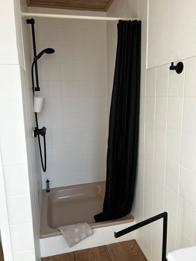 Dusche mit Vorhang im Bad der Ferienwohnung Lilit