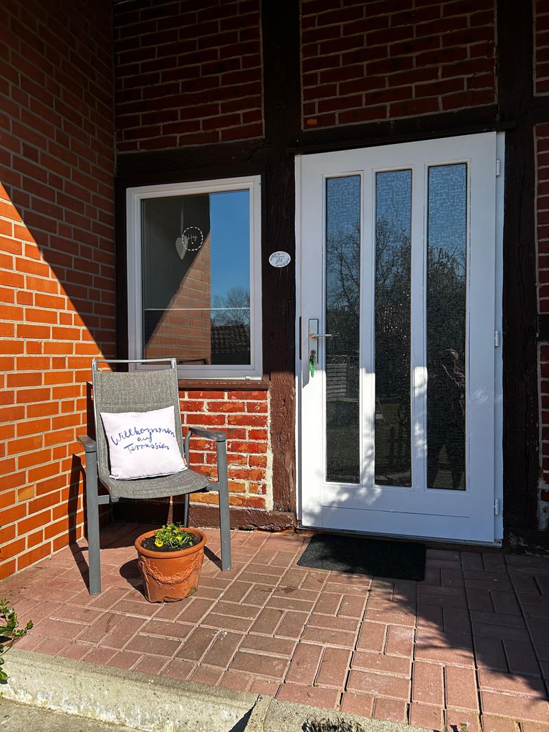 Eigener Eingang der Ferienwohnung Lilit mit Sitzplatz vor der Backsteinfassade