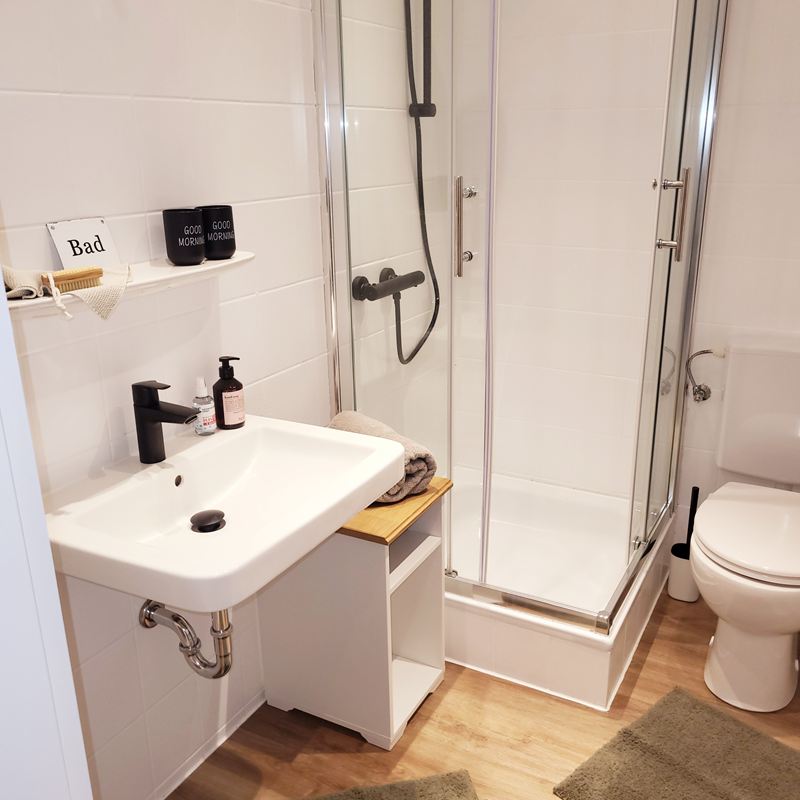 Badezimmer mit Dusche, Waschbecken und WC in der Ferienwohnung Lotta