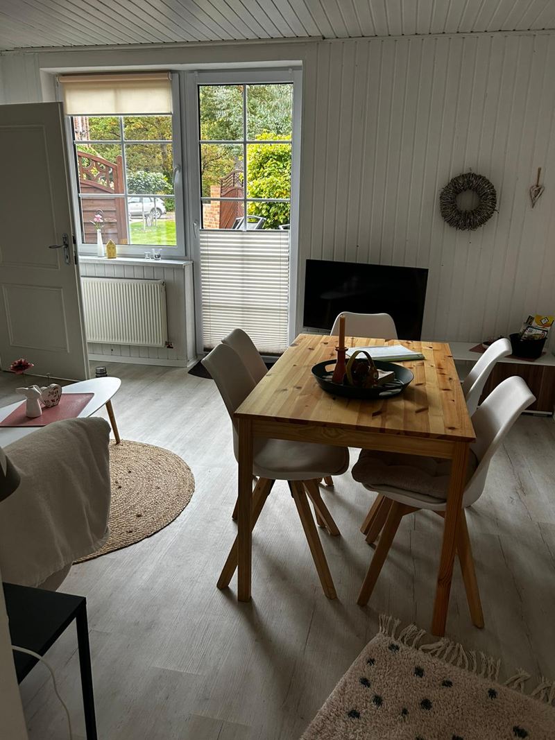 Essbereich mit Holztisch vor der Terrassentür in der Ferienwohnung Luuk